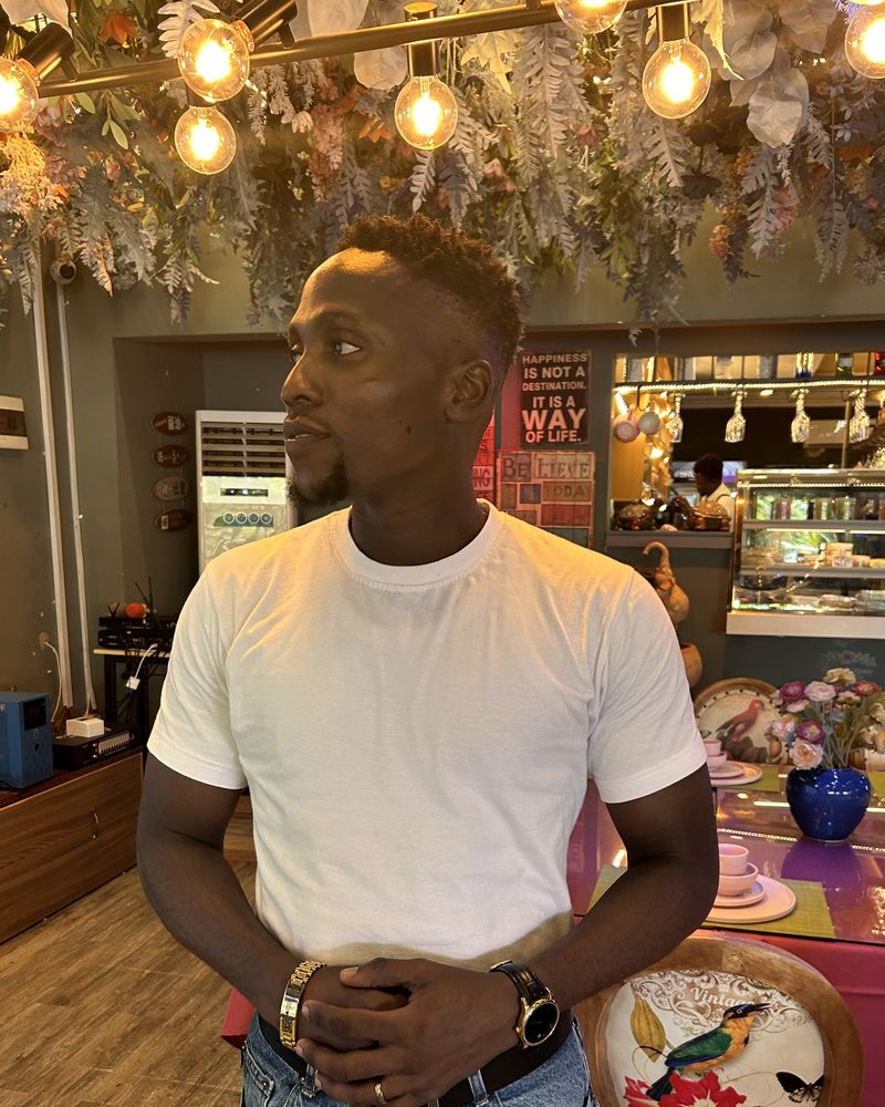 Victor in a white T-shirt in a restaurant full of hanging flowers